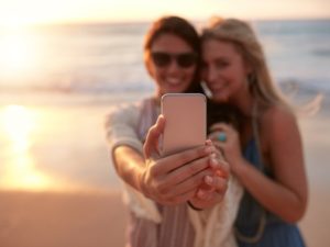 2 amis prenant un selfie au bord de la mer